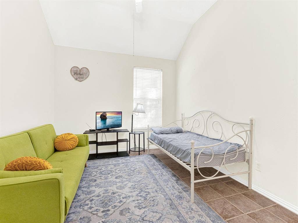 Warm tile flooring and a simple rectangular layout make this secondary room easy to personalize, with daylight reaching in through a tall window. Give overnight visitors a comfortable spot to unwind between shared meals and outings.