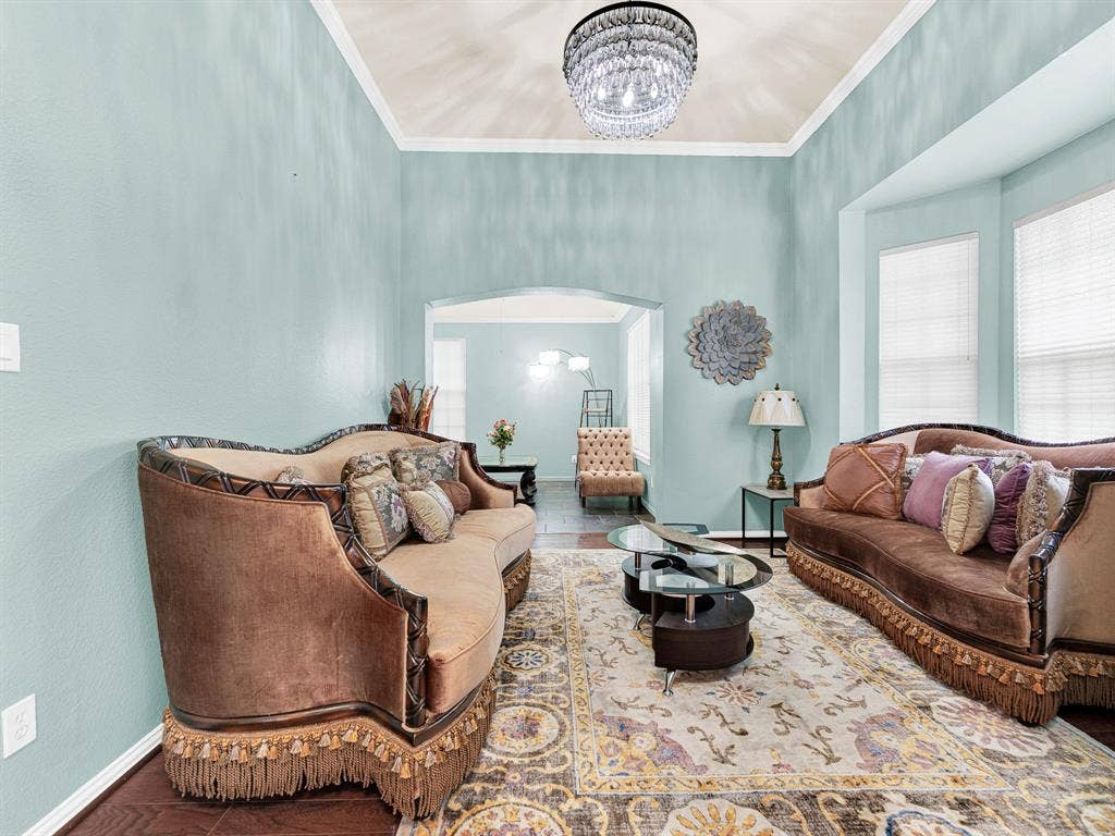 Tall ceilings and soft aqua walls give the front living room an airy feel, with a recessed window bay bringing in gentle daylight. Welcome guests here for an unhurried catch-up before the evening’s plans begin.