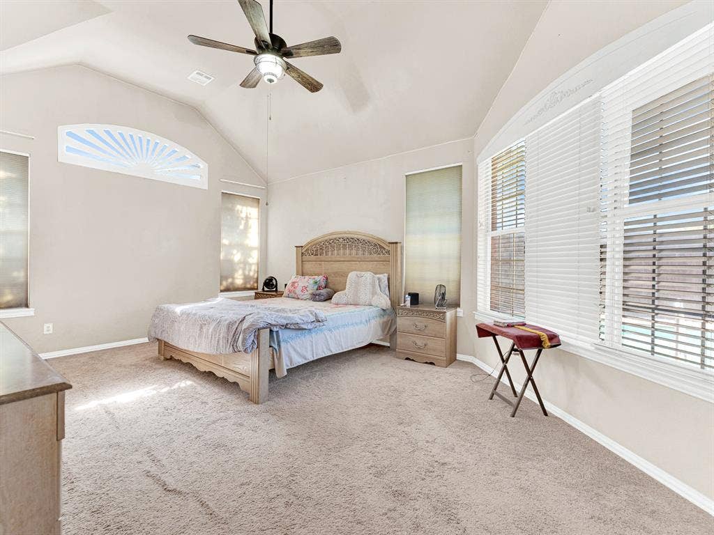 A decorative fanlight brings sky views into the primary bedroom, illuminating the upper reaches of its sculpted ceiling. Take a few peaceful minutes for morning stretches before the day gets underway.