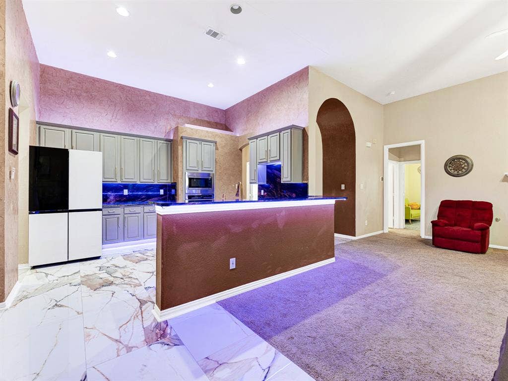 Color-selectable LED lighting traces the breakfast bar, carrying the kitchen’s ambiance into the adjoining gathering space. Match the glow to your celebration and welcome friends for snacks and conversation.