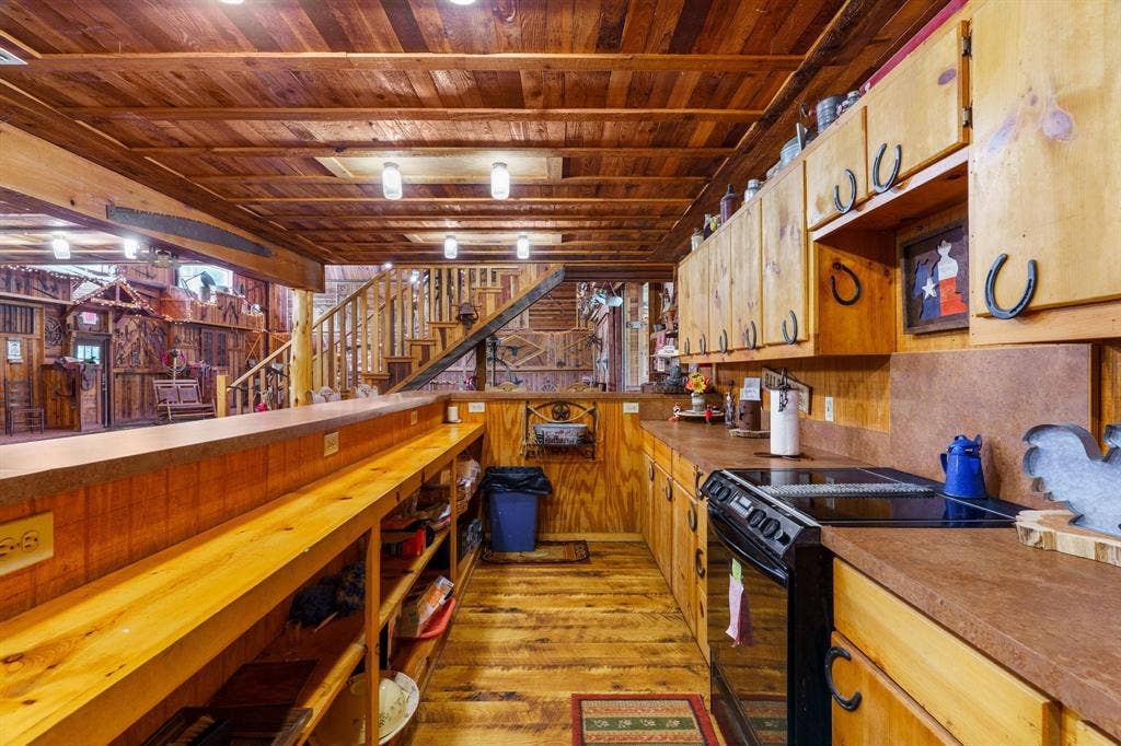 8685 FM 1827, Anna, TX 75409 Kitchen featuring tongue-and-groove wood plank ceiling, custom natural wood cabinetry, wood-finish flooring, integrated breakfast bar, and rustic metal hardware