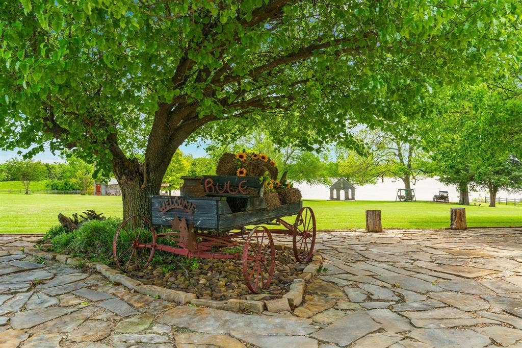 8685 FM 1827, Anna, TX 75409 Expansive grounds featuring a natural stone patio, mature shade trees, and open lawn space