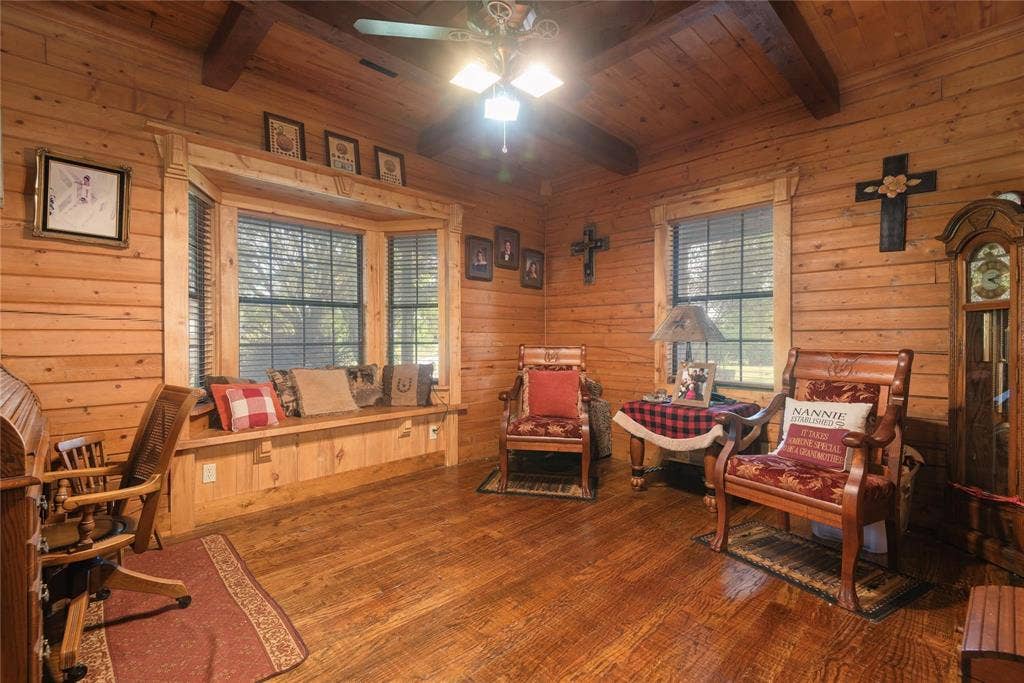 8685 FM 1827, Anna, TX 75409 Natural log walls, exposed timber ceiling beams, hardwood flooring, and a built-in window seat with decorative wood trim