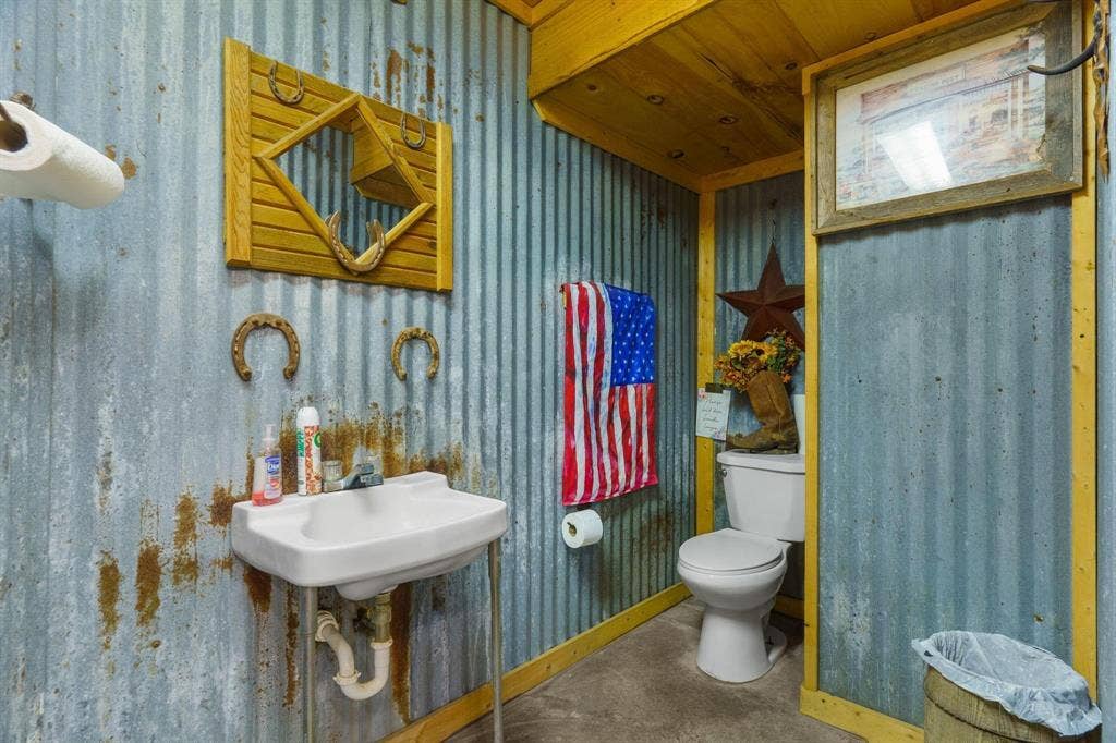 8685 FM 1827, Anna, TX 75409 Corrugated metal wall paneling with exposed wood framing, wall-mounted porcelain basin, and concrete flooring