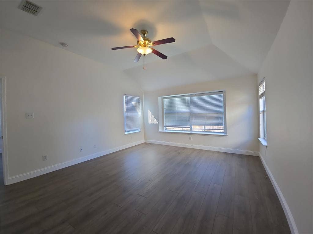 1545 Crystal Pass, Allen, TX 75002 Vaulted ceiling with a ceiling fan, multiple windows with blinds, and wood-finish flooring