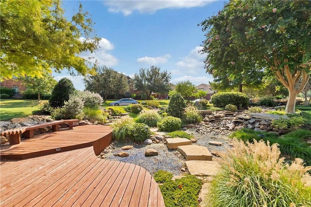 1545 Crystal Pass, Allen, TX 75002 Curved wood deck with built-in bench, natural stone landscaping, and mature trees