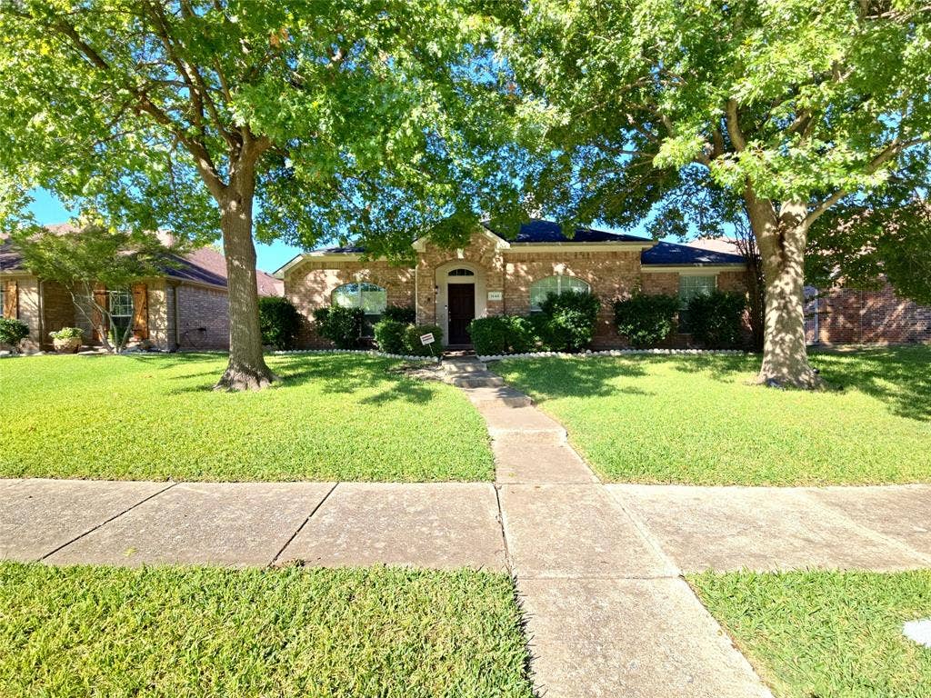 1545 Crystal Pass, Allen, TX 75002 Brick exterior home with a dark shingle roof, arched windows, and a concrete pathway