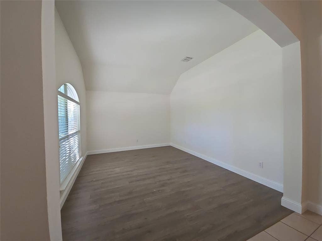 1545 Crystal Pass, Allen, TX 75002 Arch window with blind, wood-finish flooring, vaulted ceiling, and an arched entry