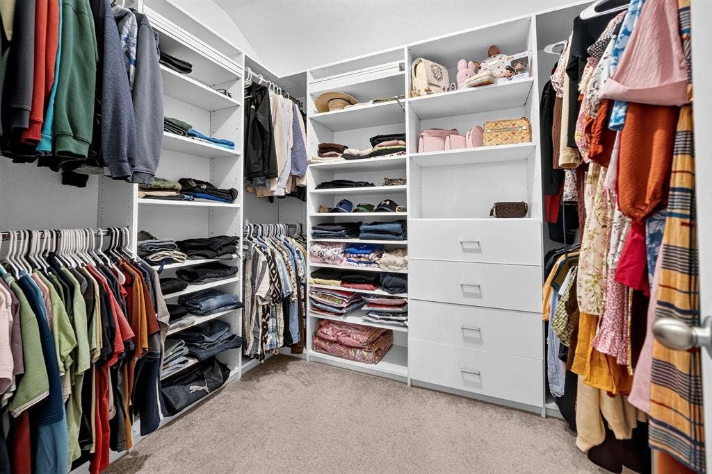 5534 Yarborough Drive, Forney, TX 75126 Built-in closet system featuring white shelving, multiple hanging rods, and integrated drawers