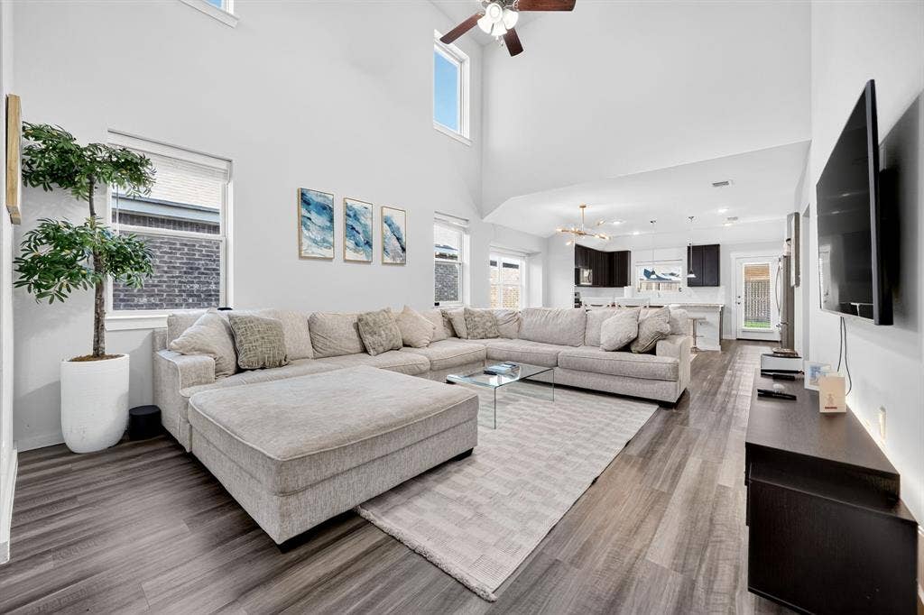 5534 Yarborough Drive, Forney, TX 75126 Vaulted ceiling with a ceiling fan, elevated windows, wood-finish flooring, and an open-concept layout