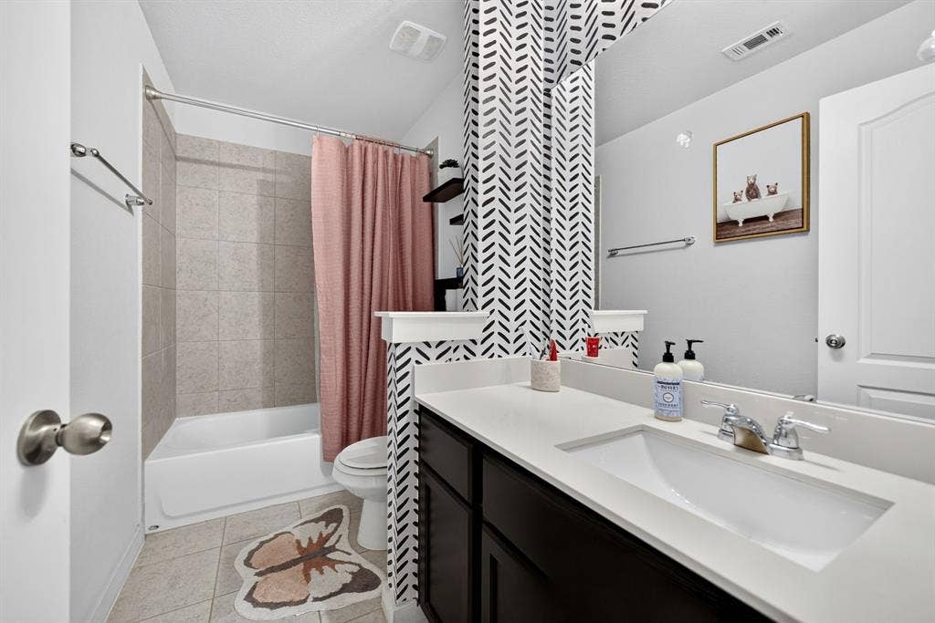5534 Yarborough Drive, Forney, TX 75126 Bathroom featuring a vanity with an integrated sink, polished chrome faucet, full-width mirror, and a tiled tub/shower combination