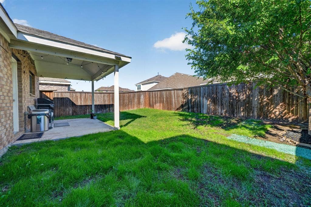 5534 Yarborough Drive, Forney, TX 75126 Covered patio with string lighting, concrete flooring, and a full privacy fence