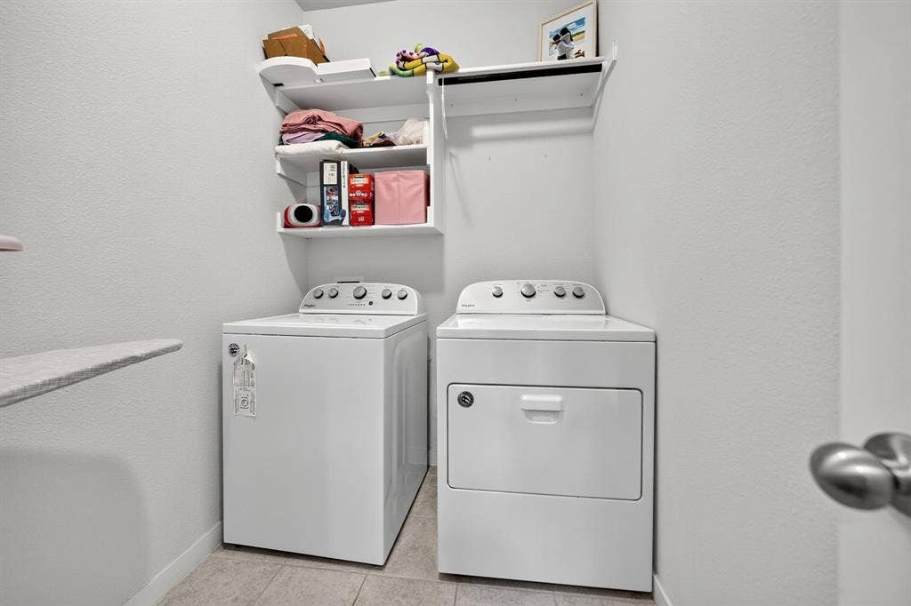 5534 Yarborough Drive, Forney, TX 75126 Dedicated laundry room featuring side-by-side white appliances, including a top-load washer and electric dryer