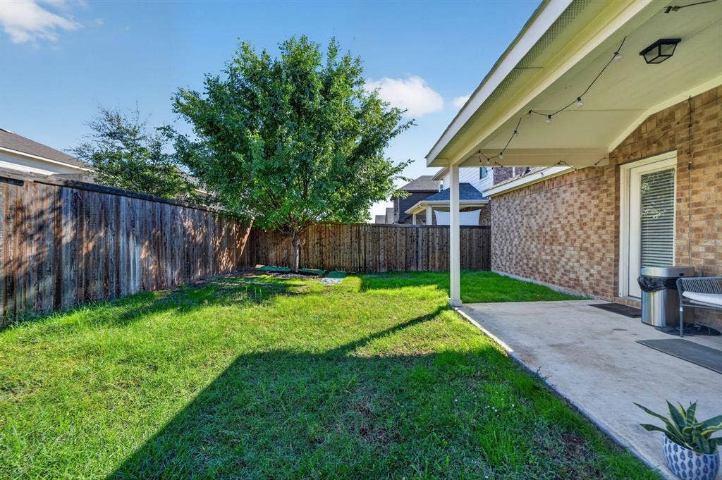 5534 Yarborough Drive, Forney, TX 75126 Spacious backyard oasis featuring a mature shade tree, manicured lawn, and wooden privacy fencing