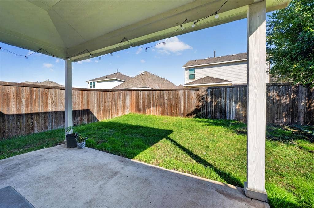 5534 Yarborough Drive, Forney, TX 75126 Covered patio with concrete flooring overlooking a spacious, level lawn bordered by wood-finish fencing
