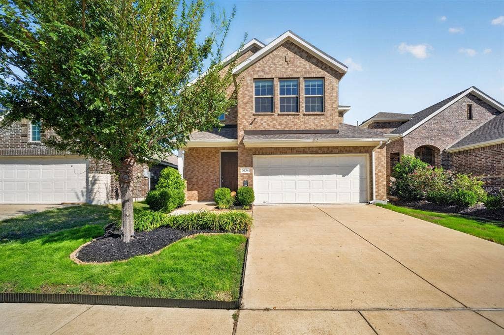 5534 Yarborough Drive, Forney, TX 75126 Brick exterior with an attached two-car garage, concrete driveway, and front lawn with mature tree and landscaping