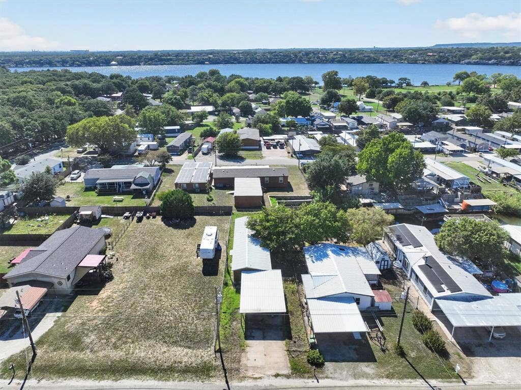 6624 Dayla Court, Granbury, TX 76049 Expansive body of water, distant tree lines, and a residential area with various roof types
