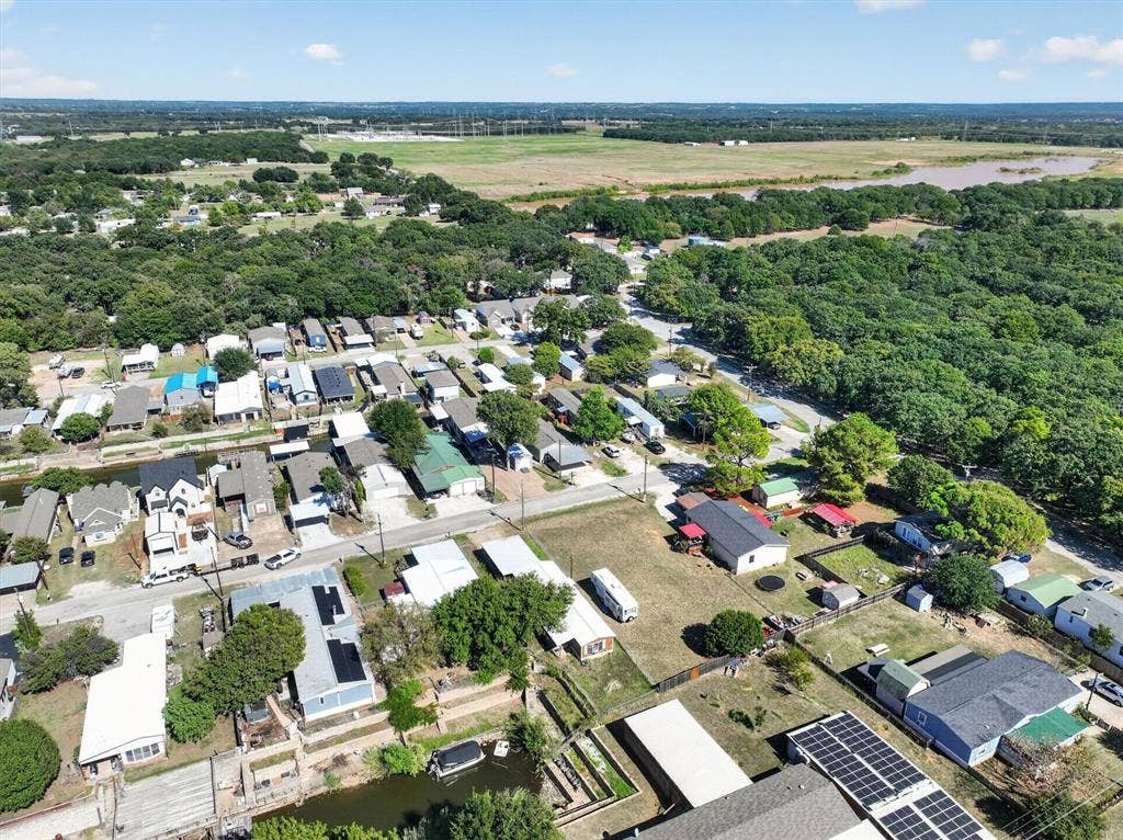 6624 Dayla Court, Granbury, TX 76049 Aerial perspective showcasing a residential community with abundant mature trees and a substantial body of water