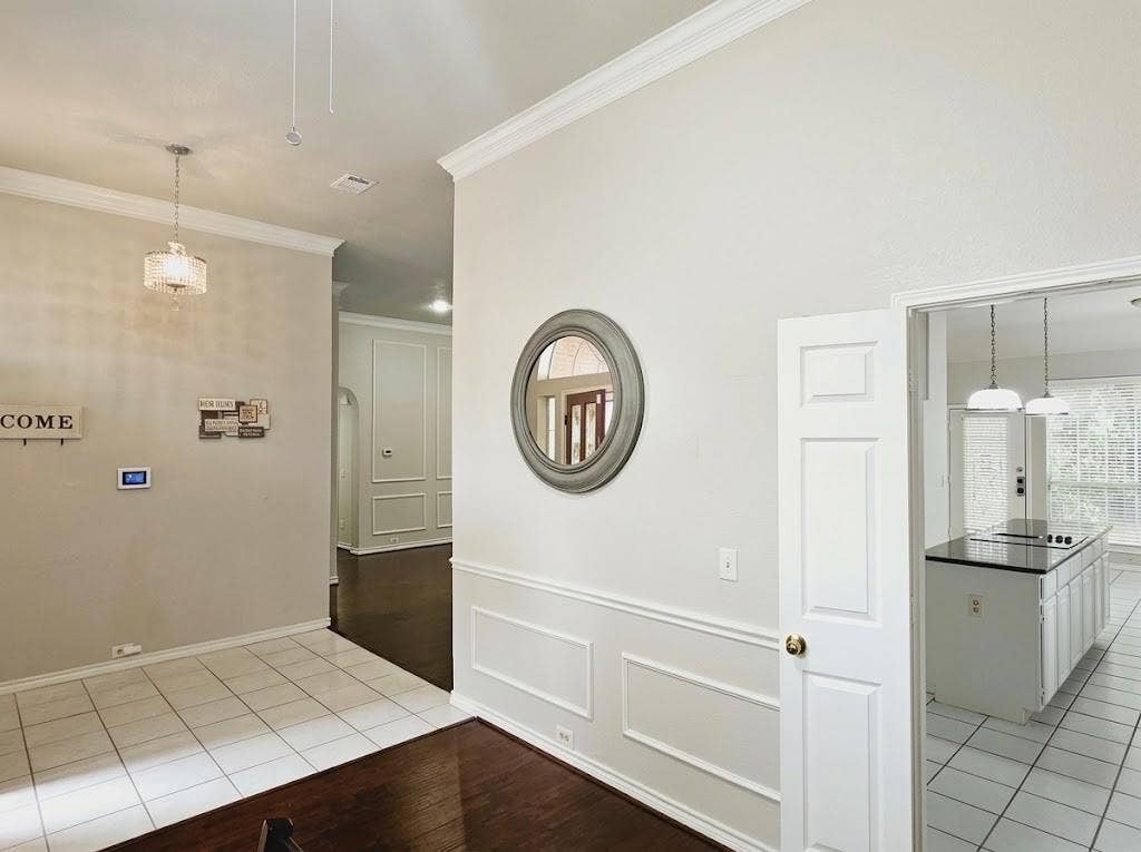 2609 Townshed Drive, Garland, TX 75044 Tile flooring, wood-finish flooring, crown molding, wainscoting, and a kitchen island with pendant lighting