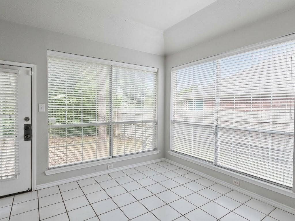 2609 Townshed Drive, Garland, TX 75044 White tile flooring, multiple large windows, white window blinds, white door, and light-colored walls
