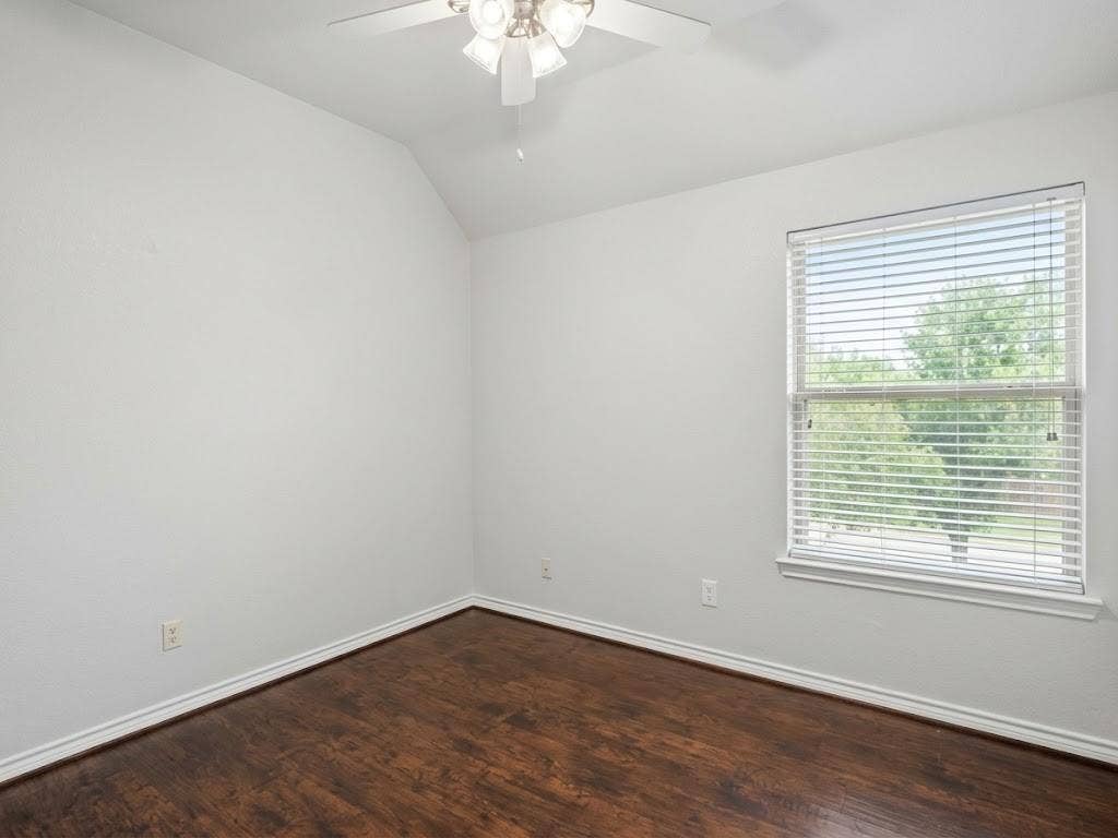 2609 Townshed Drive, Garland, TX 75044 Hardwood-look flooring with white trim, vaulted ceiling, and ceiling fan