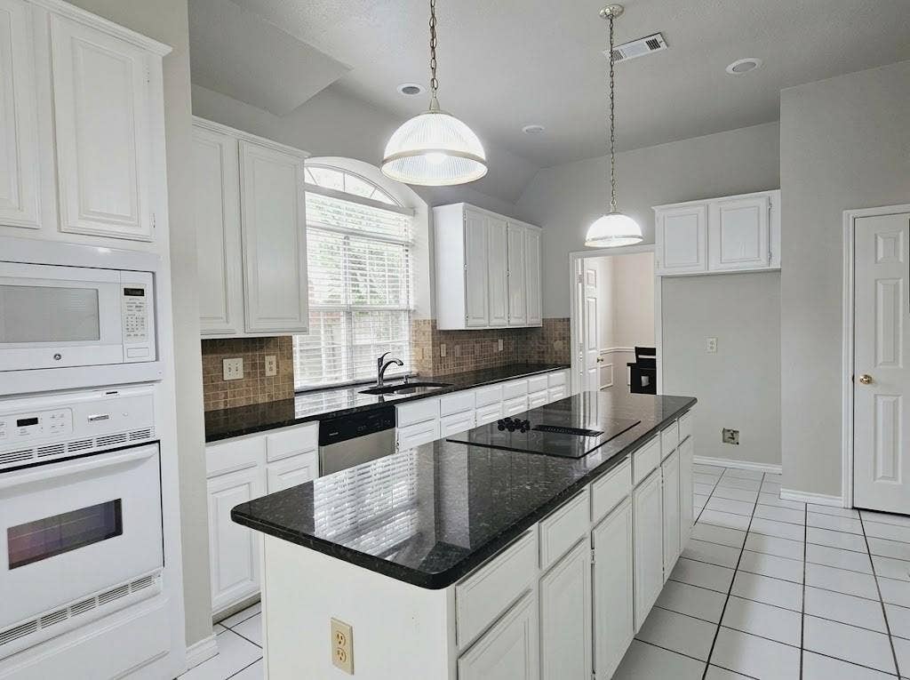 2609 Townshed Drive, Garland, TX 75044 Kitchen featuring white cabinetry, dark stone countertops, an integrated cooktop, and built-in appliances