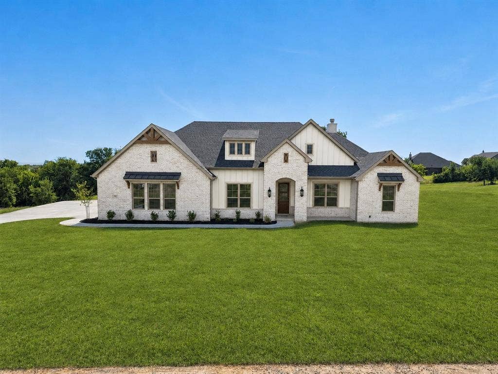 131 Oak Meadow Lane, Weatherford, TX 76085 White brick and board and batten exterior with a dark shingle roof, featuring multiple gables, and a concrete driveway