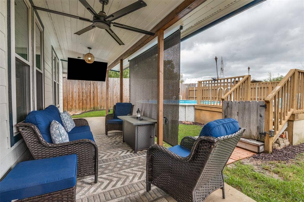 Covered patio with a beadboard ceiling, wood-beam accents, and a ceiling fan