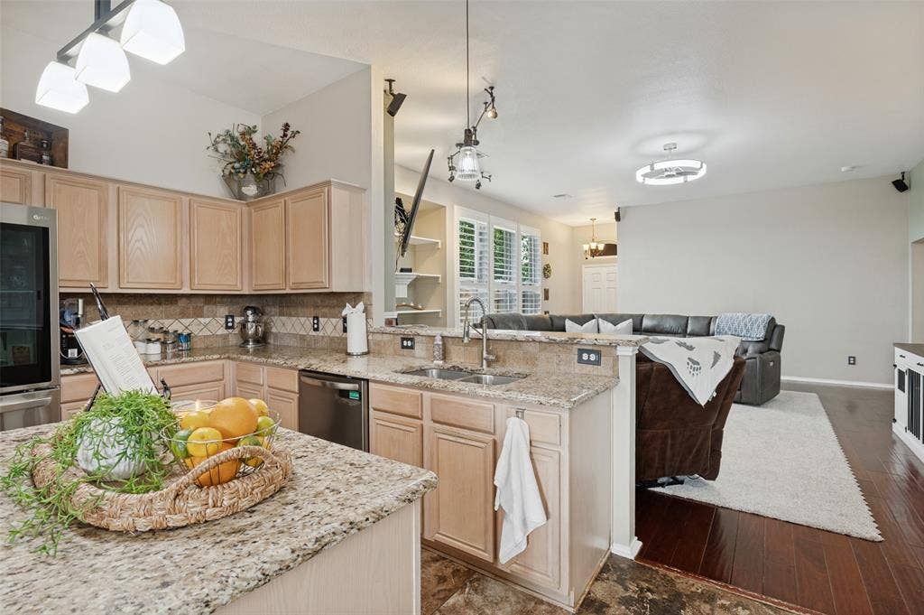 Kitchen featuring light wood-finish cabinetry, granite countertops, and stainless steel appliances