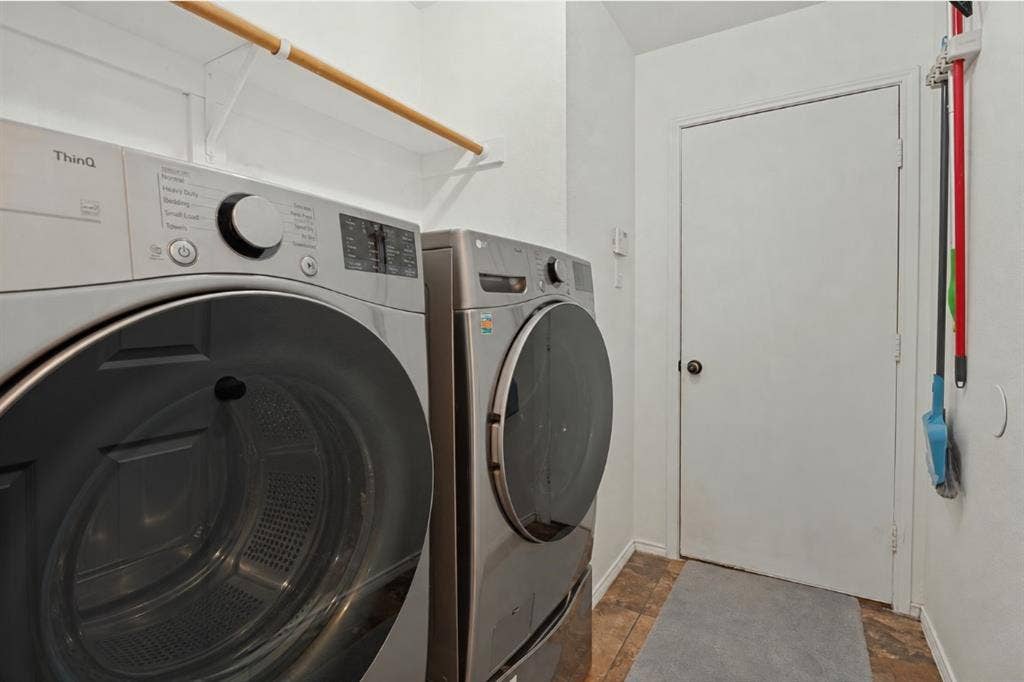 Laundry area featuring an overhead hanging rod and patterned floor tiles