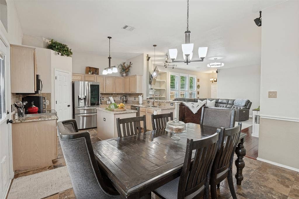 Kitchen featuring stainless steel appliances, light-toned cabinetry, and an eat-at island