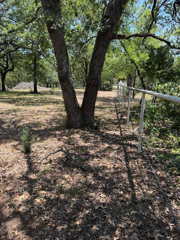 2300 Spring Mountain Road, Cross Roads, TX 76227 Mature oak trees provide natural shade throughout the pastoral grounds, complemented by rustic split-rail fencing that defines the property perimeter