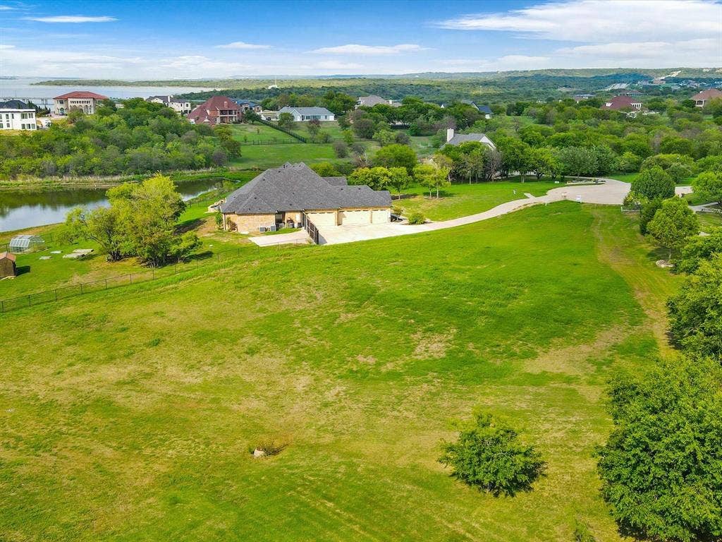 1036 Lighthouse Court, Grand Prairie, TX 75104 Expansive green landscape with a large residential structure featuring a multi-car garage