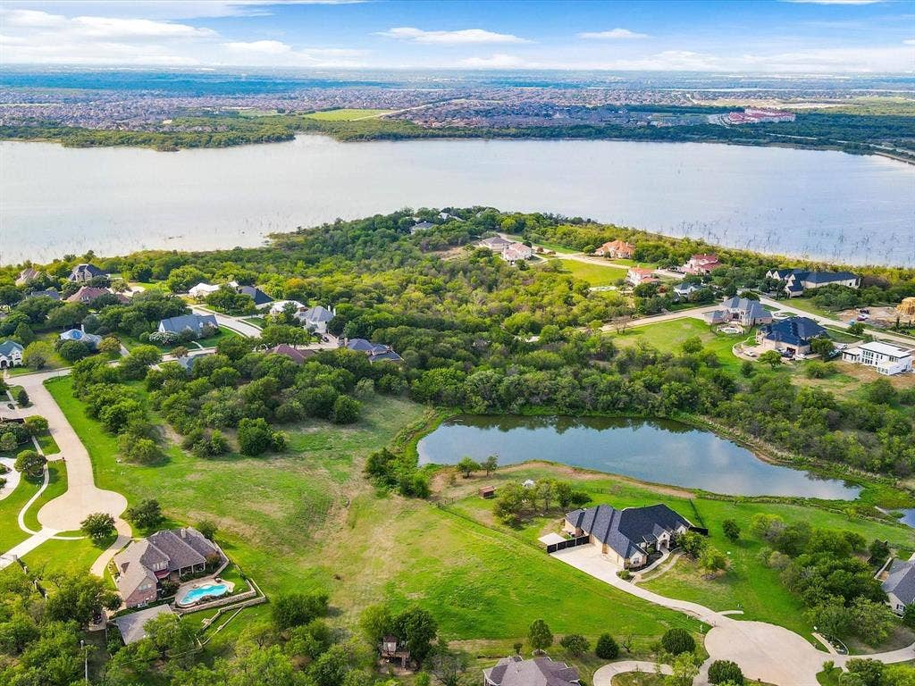 1036 Lighthouse Court, Grand Prairie, TX 75104 Expansive residential area featuring a large body of water, lush green landscaping, and multiple properties with private pools