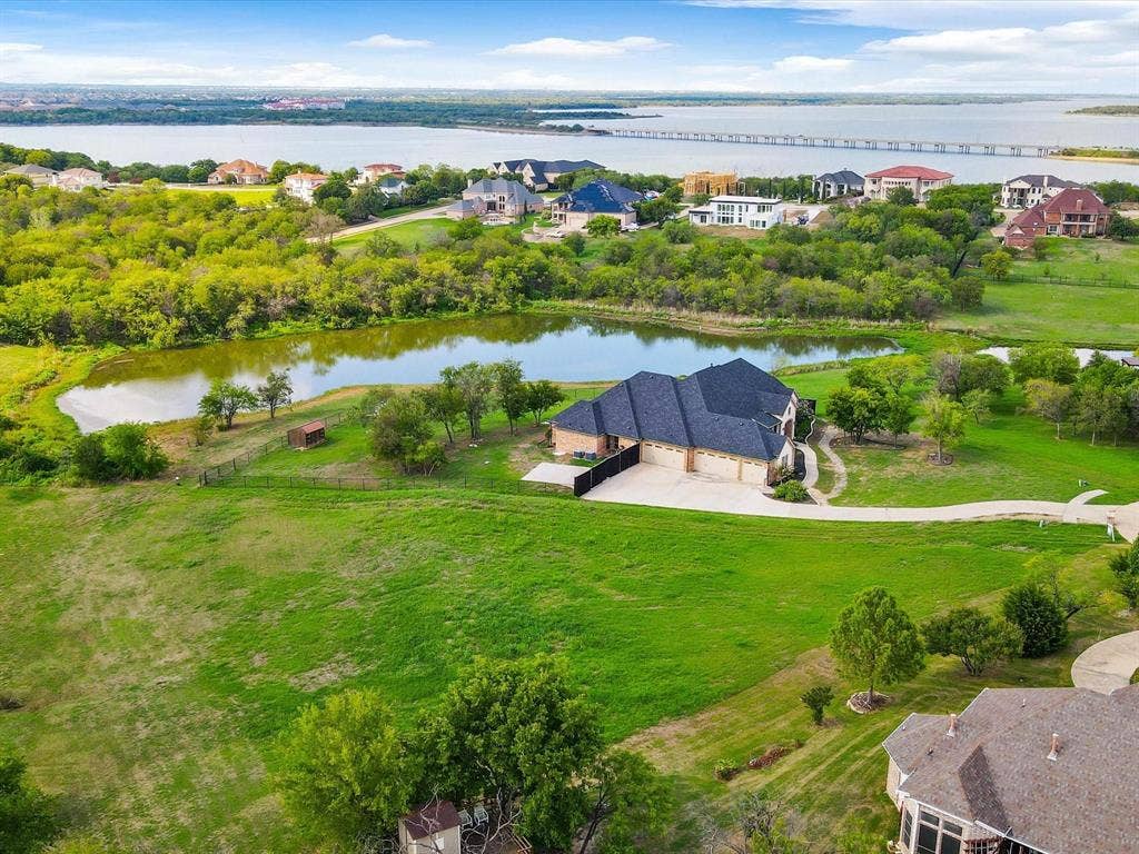 1036 Lighthouse Court, Grand Prairie, TX 75104 Expansive property featuring a private pond, extensive green space, and a waterfront backdrop