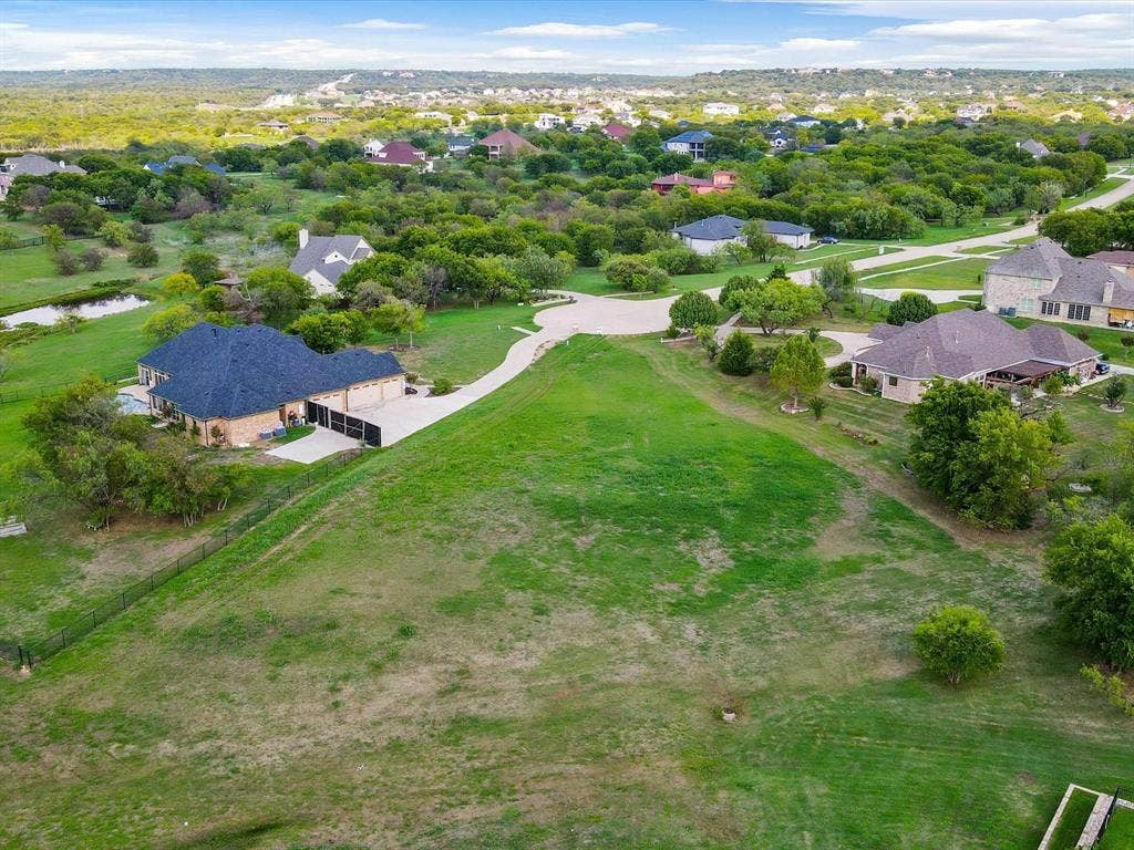 1036 Lighthouse Court, Grand Prairie, TX 75104 Expansive green space with distant residential properties, mature trees, and a small pond