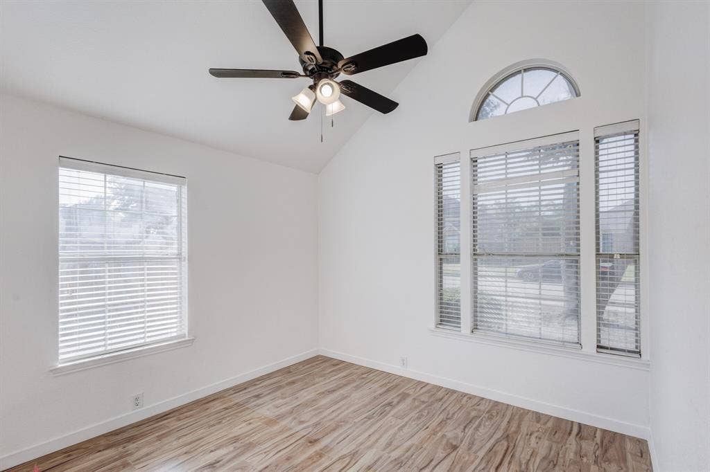 1306 Bentley Drive, Carrollton, TX 75006 Empty room with light hardwood / wood-style flooring, ceiling fan, and vaulted ceiling