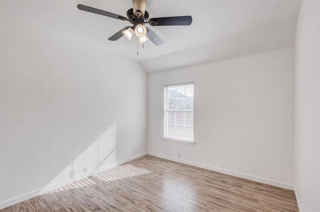 1306 Bentley Drive, Carrollton, TX 75006 Unfurnished room with vaulted ceiling, light hardwood / wood-style flooring, and ceiling fan