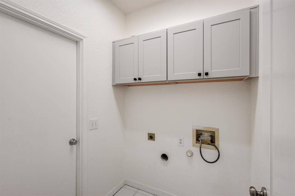 1306 Bentley Drive, Carrollton, TX 75006 Laundry room featuring hookup for an electric dryer, gas dryer hookup, hookup for a washing machine, tile patterned floors, and cabinets