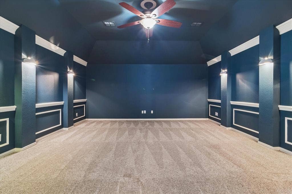 8323 Albritton Drive, Frisco, TX 75036 Carpeted room featuring a ceiling fan with integrated lighting, wall sconces, and decorative wall molding