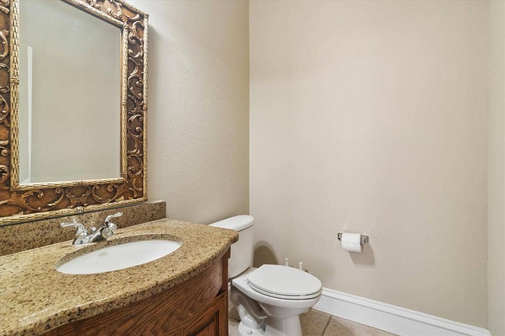 8323 Albritton Drive, Frisco, TX 75036 Vanity with granite countertop, integrated sink, and wood-finish cabinetry