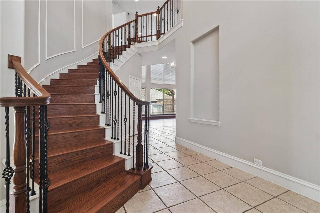 8323 Albritton Drive, Frisco, TX 75036 Curved staircase with wood-finish treads and wrought iron balusters