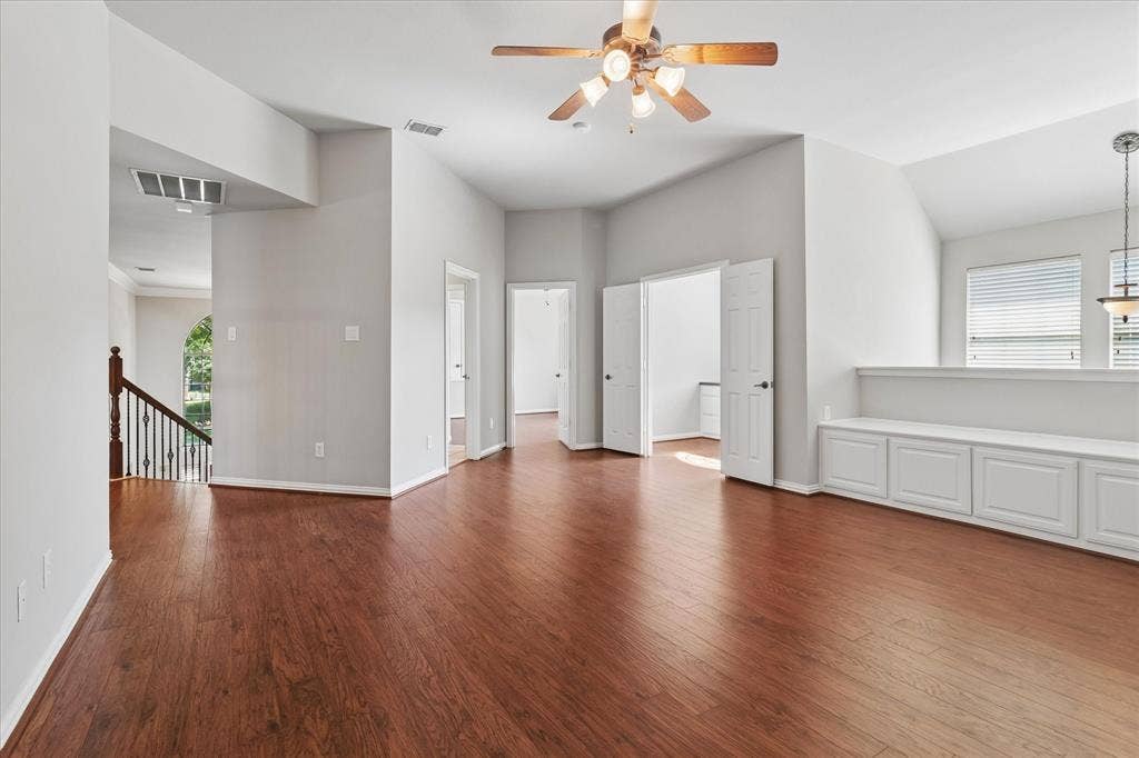 8323 Albritton Drive, Frisco, TX 75036 Warm wood-finish flooring, vaulted ceilings, and a built-in storage bench with panel-front cabinetry