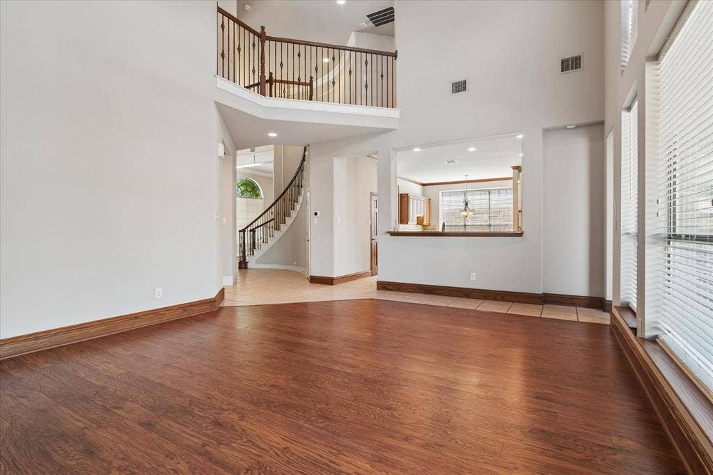8323 Albritton Drive, Frisco, TX 75036 Expansive interior with wood-finish flooring, a spiral staircase, and an upper-level balcony