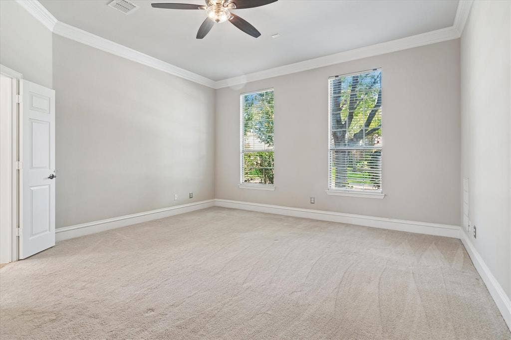 8323 Albritton Drive, Frisco, TX 75036 Neutral color palette with crown molding, ceiling fan with integrated lighting, two windows with blinds, and light-toned carpeting