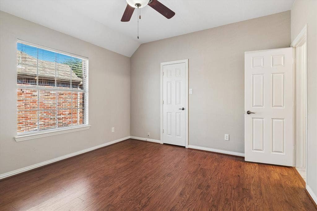 8323 Albritton Drive, Frisco, TX 75036 Vaulted ceiling with a ceiling fan, wood-finish flooring, and a large window with horizontal blinds
