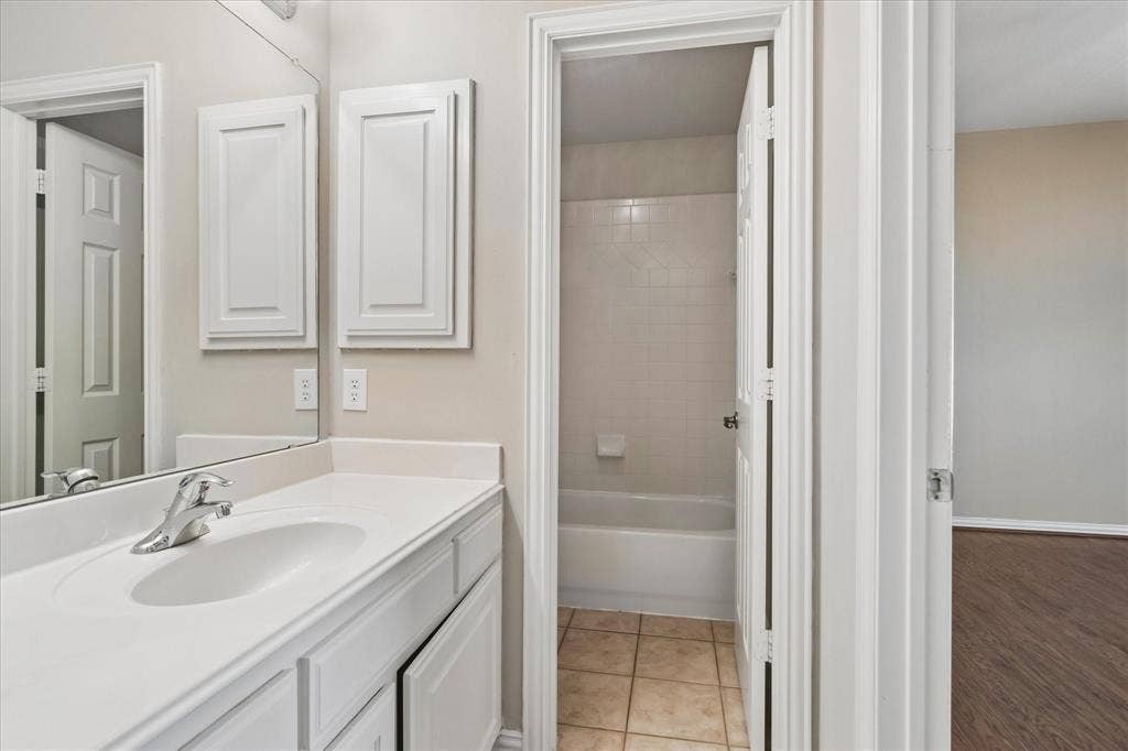 8323 Albritton Drive, Frisco, TX 75036 Bathroom vanity with integrated sink, chrome faucet, and white cabinetry