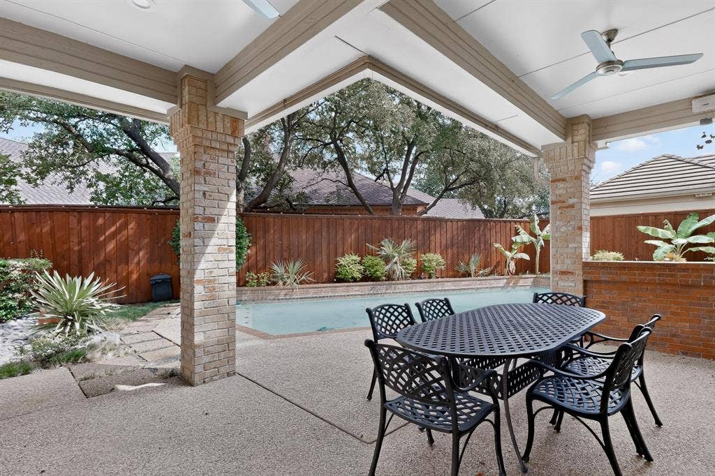 4536 Briar Oaks Circle, Dallas, TX 75287 Covered patio with exposed aggregate flooring, brick columns, and ceiling fans