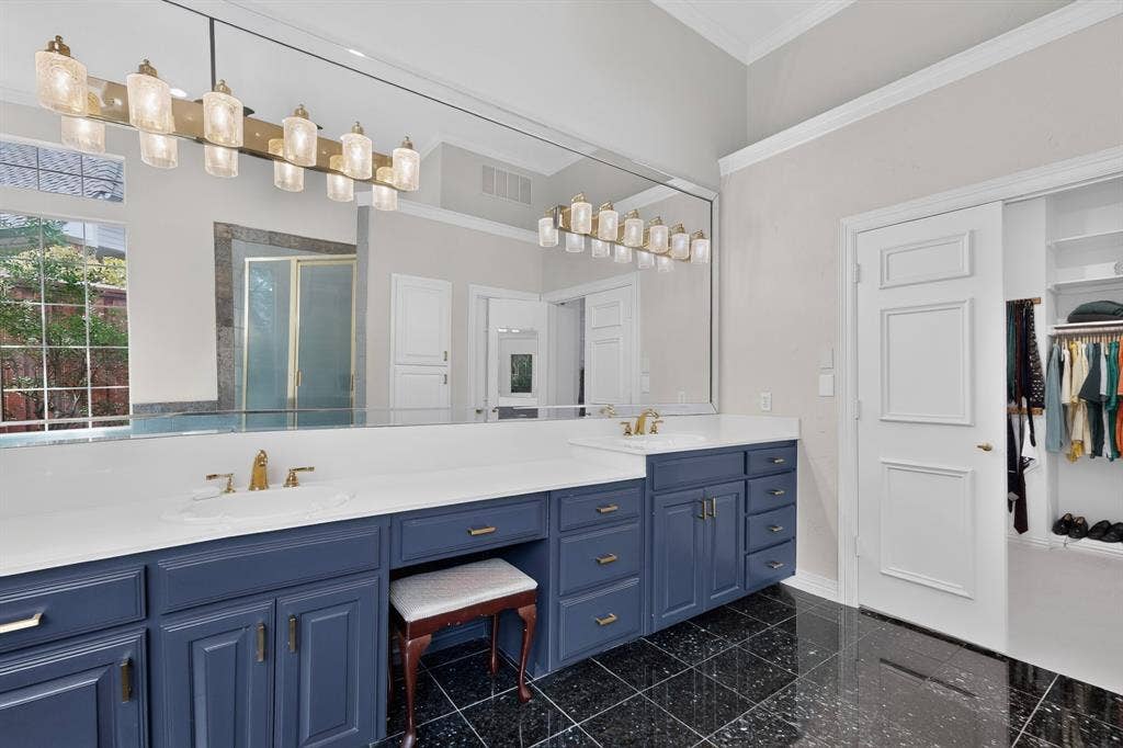 4536 Briar Oaks Circle, Dallas, TX 75287 Bathroom featuring a large vanity with dual sinks, blue cabinetry, white countertops, a full-width mirror, and black tile flooring