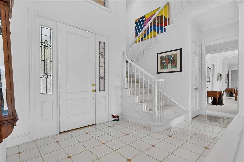 4536 Briar Oaks Circle, Dallas, TX 75287 Entryway featuring a white paneled door with decorative sidelights, a white staircase with carpeted treads, and tiled flooring